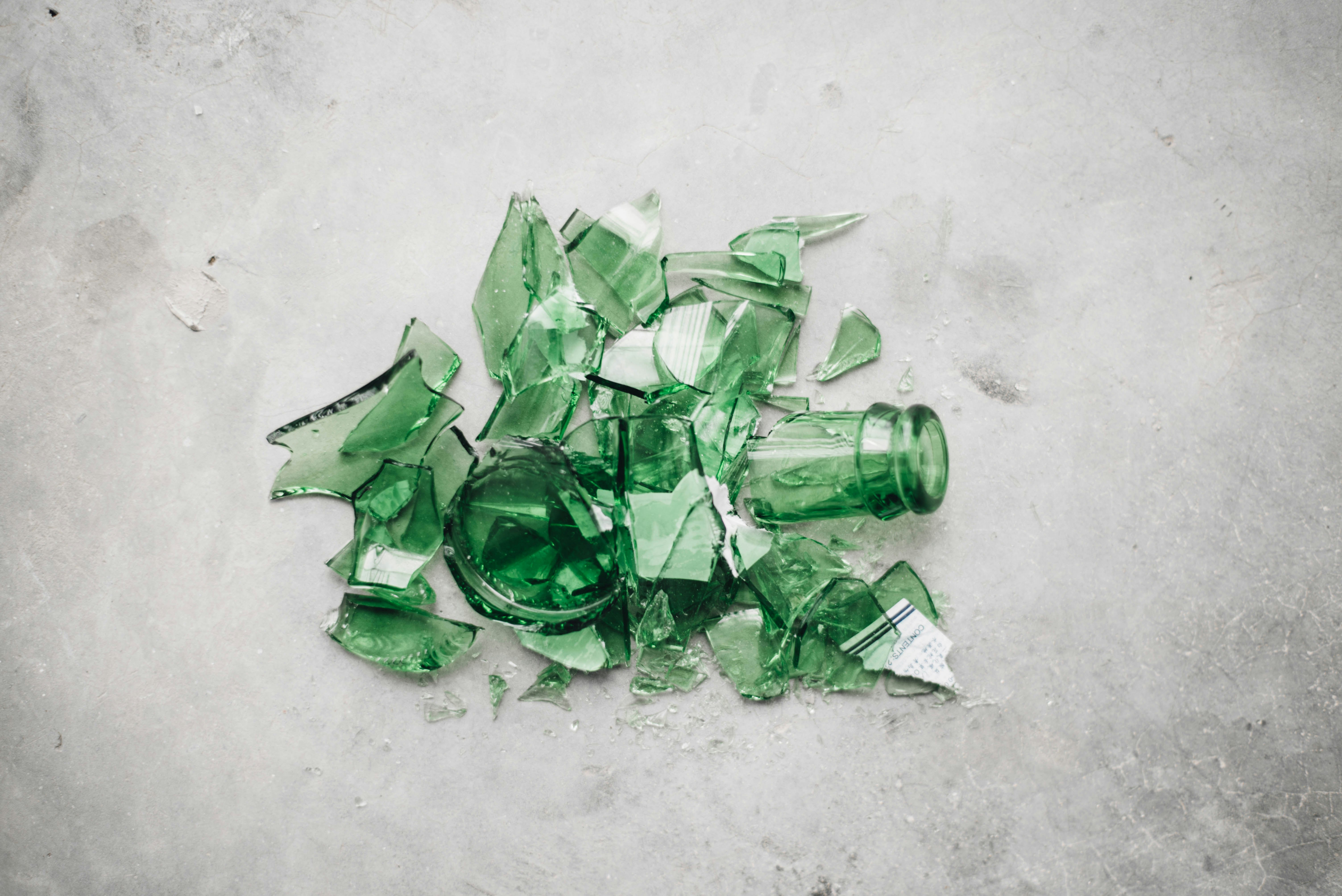 broken green glass bottle on the ground